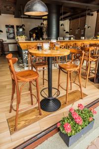 un restaurante con mesas de madera, sillas y flores en Kyjovský pivovar - hotel, restaurace, pivní lázně, en Kyjov