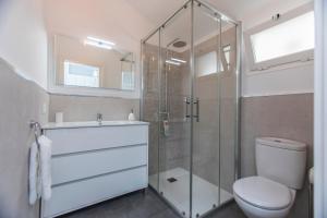 a bathroom with a toilet and a glass shower at Casa Alma in Marbella +23 photos