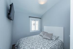 a blue bedroom with a bed and a television at Casa Alma in Marbella