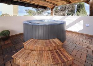 a hot tub and a bench on a patio at Villa Carmel Boutique Hotel in Haifa