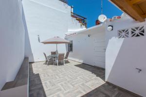 a patio with a table and chairs and an umbrella at Casa Alma in Marbella