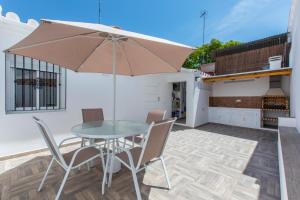 a patio with a glass table and chairs and an umbrella at Casa Alma in Marbella