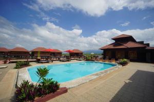 una piscina en un complejo con mesas y sillas en Shwe Inn Tha Floating Resort, en Ywama