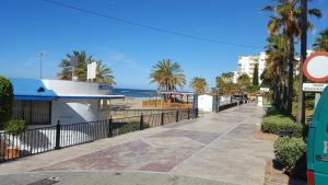 a sidewalk next to a beach with palm trees at Casa Alma in Marbella