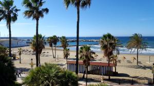 a view of a beach with palm trees and the ocean at Casa Alma in Marbella