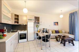 a kitchen and living room with a couch and a table at Giorgi's Blue Apartments in Kalathas