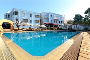 a large swimming pool in front of some buildings at Giorgi's Blue Apartments in Kalathas