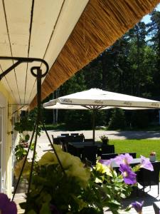 a patio with an umbrella and tables and chairs at Ranna Villa Farm in Küdema