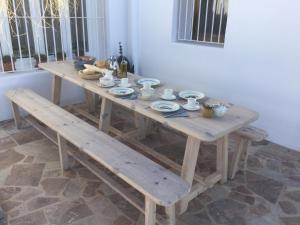 een houten tafel en banken in een kamer bij CASABAH bed & breakfast in Carboneras