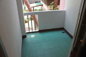 een kamer met een balkon en een groene vloer bij Soi 5 Apartment in Pattaya