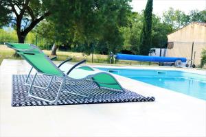 a pair of chairs sitting next to a swimming pool at Terre de Sel in Grimaud