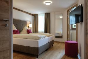 pokój hotelowy z łóżkiem i telewizorem z płaskim ekranem w obiekcie Alpengasthof zur Post w mieście Schattwald