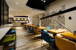 a restaurant with wooden tables and blue chairs at CHECK inn Taichung Zhongshan in Taichung