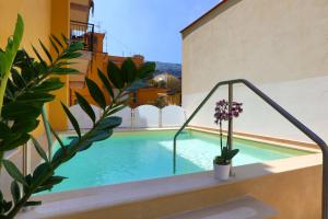 a pool on the side of a building with plants at Hotel Astoria Sorrento in Sorrento