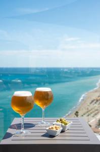 two glasses of beer and a plate of food on a table at Hotel El Puerto by Pierre Vacances in Fuengirola
