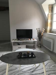 sala de estar con mesa y TV en 4 Rue Jean Jaurès en Sarlat-la-Canéda