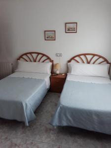 two beds sitting next to each other in a bedroom at Hostal González in Oviedo