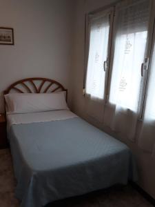 a small bedroom with a bed and a window at Hostal González in Oviedo
