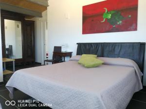ein Schlafzimmer mit einem Bett mit einem grünen Kissen darauf in der Unterkunft B&B Brezza Delle Egadi in Marsala