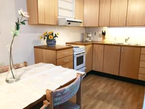 a kitchen with a table with a vase of flowers at Villa Holmen, ground floor apartment in Balestrand