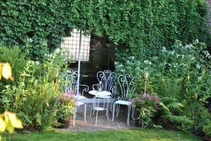 eine Terrasse mit Stühlen und einem Tisch im Garten in der Unterkunft Clos de Royaucourt in Royaucourt