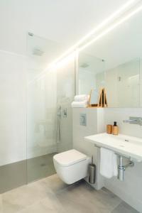 a bathroom with a toilet and a sink and a shower at Sea Breeze Apartments in Cala Millor +52 photos