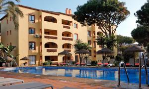 a hotel with a swimming pool in front of a building at Macdonald Doña Lola Resort in La Cala de Mijas