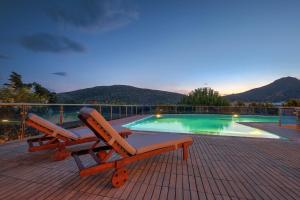 une terrasse avec un banc et une piscine dans l'établissement Sounio Aeolos Villas, à Cap Sounion