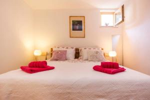 ein Schlafzimmer mit einem großen weißen Bett mit roten Kissen in der Unterkunft Apartment Premsai in Rovinj