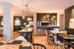 a restaurant with tables and chairs and a kitchen at Up Rooms Vic Hotel in Vic
