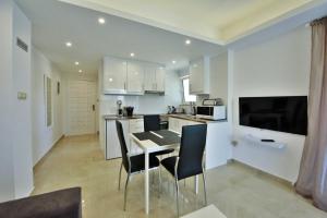 une cuisine et une salle à manger avec une table et des chaises dans l'établissement Athena Apartment, à Artemi