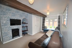 a living room with a couch and a fireplace at Abbey Cottage in Shrewsbury