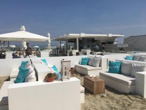 - un ensemble de canapés blancs assis sur une plage dans l'établissement Apartment Zin in Zee, à Knokke-Heist