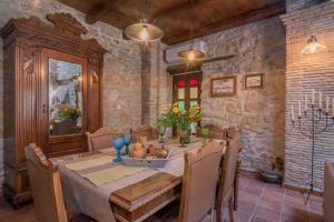 a dining room with a table and chairs and a stone wall at Villa Galanoussa in Zakynthos