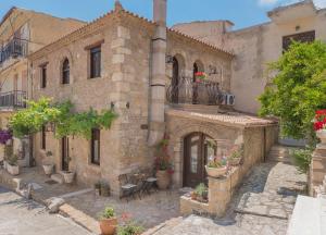 an old brick building with potted plants on it at Villa Galanoussa in Zakynthos