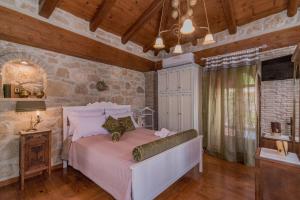 a bedroom with a bed and a stone wall at Villa Galanoussa in Zakynthos