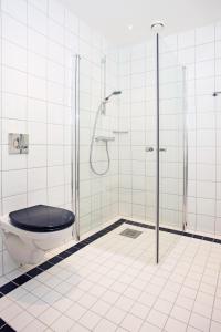 a bathroom with a shower with a toilet and a glass door at Thon Hotel Opera in Oslo