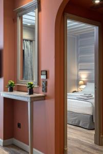 a bedroom with a mirror and a bed at Estia Boutique Apartments in Athens