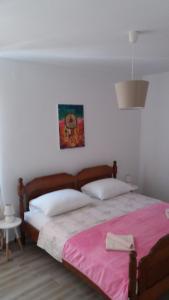 a bedroom with a large bed with a pink blanket at Flamingo in Šibenik