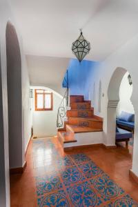 un couloir avec des escaliers et un mur bleu dans l'établissement Dar Carlos, à Chefchaouen