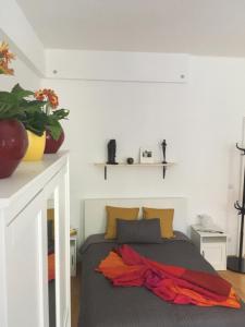 a bedroom with a bed with an orange blanket on it at Enjoy Apartman in Sopron