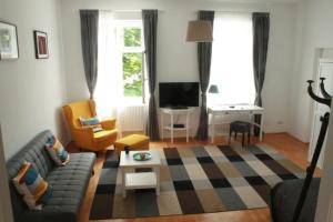 uma sala de estar com um sofá e uma mesa em Enjoy Apartman em Sopron