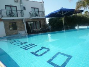 a swimming pool in front of a house with an umbrella at Esperando in Maroni