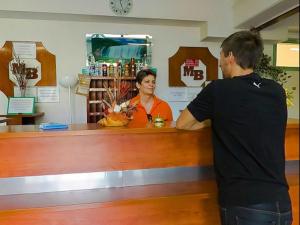 a man and a woman standing at a cash register at Botax Motel in Eger