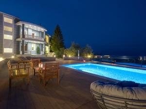 a villa with a swimming pool at night at Mont Bleu Luxury Villa in Zakynthos Town