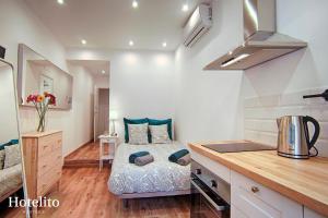 a small bedroom with a bed and a kitchen at Hotelito Boutique Badalona. in Badalona