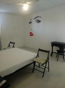 アヴォラにあるCasa Vacanza Nerodavolaのベッドルーム1室(ベッド1台、椅子、ピアノ付)