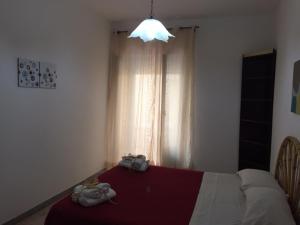 ein Schlafzimmer mit einem roten Bett und einer Lampe in der Unterkunft La Punta della Signora in Marina di Camerota