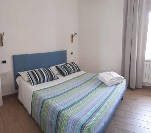 a bedroom with a large bed with a striped blanket at Civico 1 in San Mauro Cilento