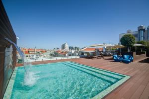 a pool on the roof of a building with a fountain at Jupiter Lisboa Hotel in Lisbon